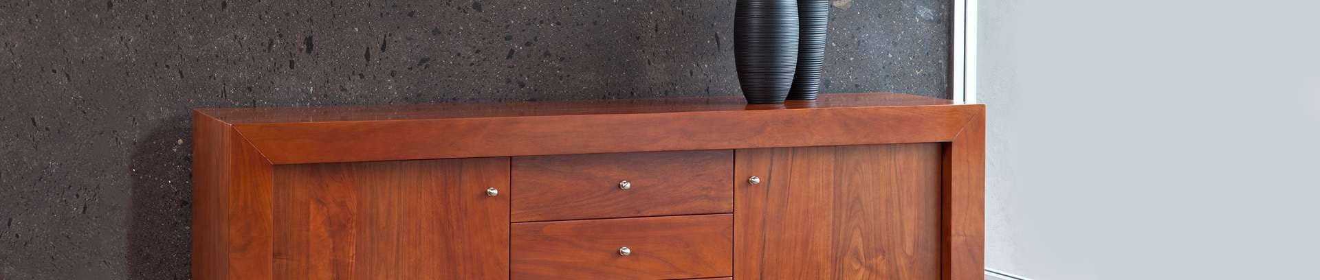 Wide wooden cabinet with a vase on top