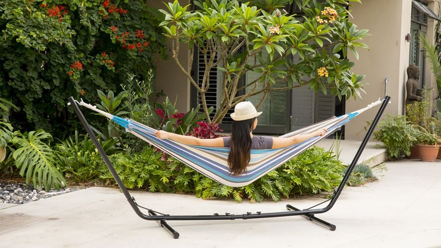 A person in a hammock overlooking a small garden