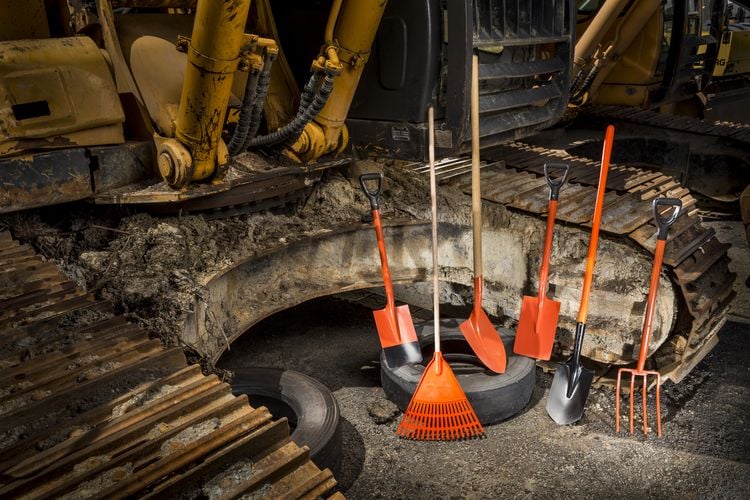 Array of digging tools leaning against an excavator