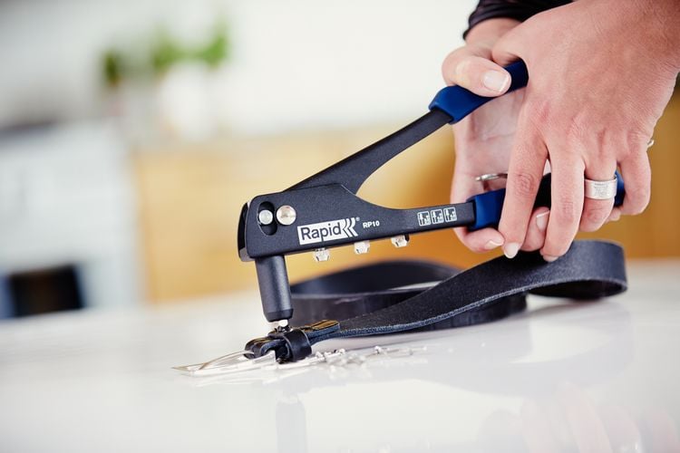 Person fixing belt with rivet gun