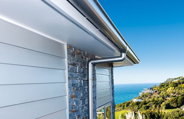 House exterior with shiny metallic PVC drain pipe