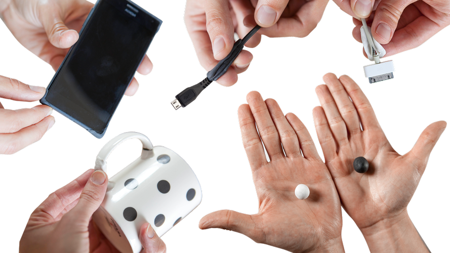 A phone, charging cords and a mug being fixed with flexible putty 