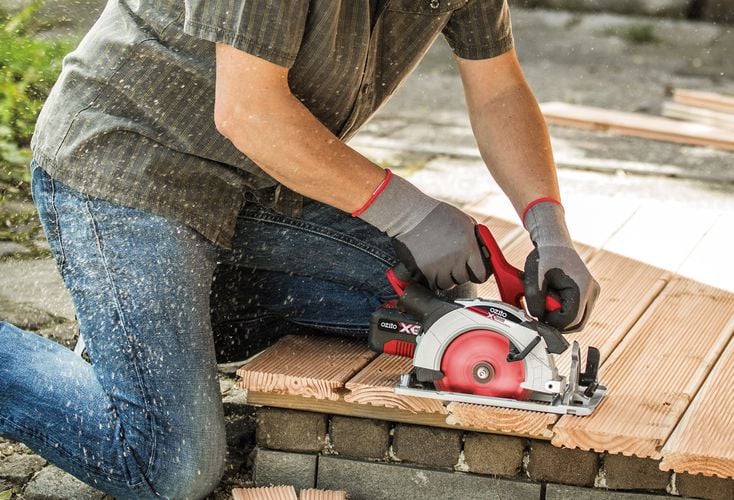Person using cordless circular saw to cut timber