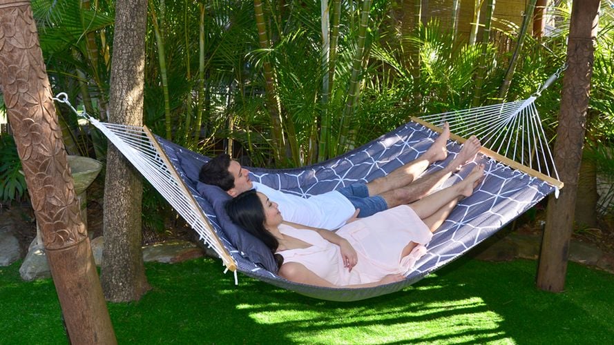 A couple in a hammock in front of a bamboo grove