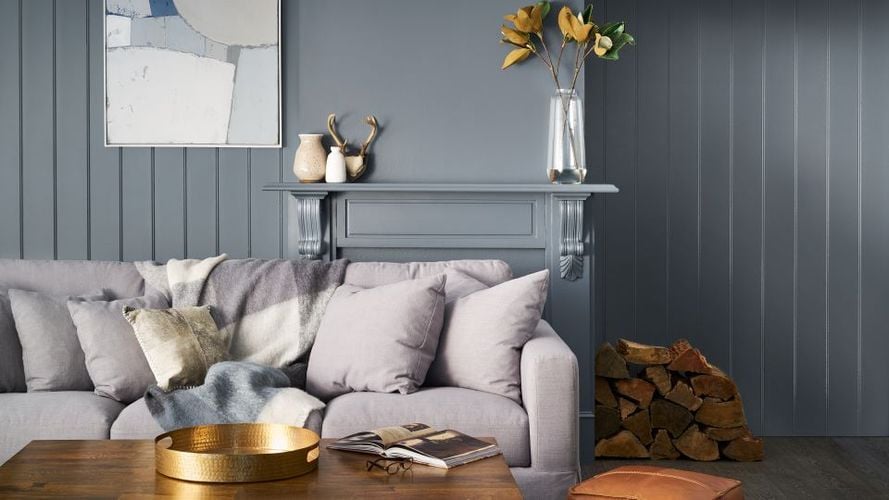 Lounge room with couch, coffee table, mantle piece and firewood