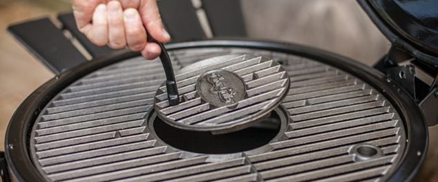 Person removing grilling plate from bbq