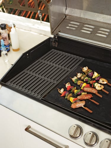 Meat and vegetable skewers sitting on barbecue