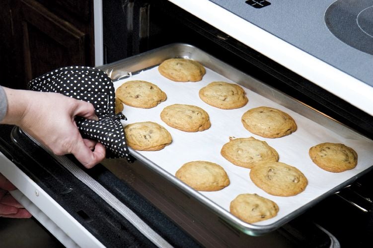 Person removing tray of cookies from oven