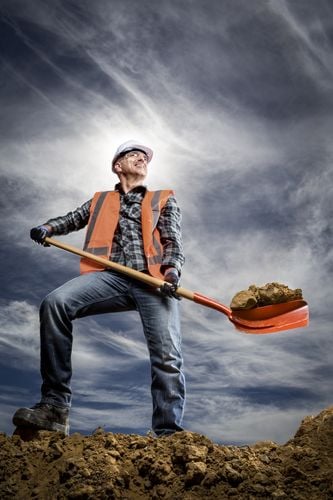 Man with a shovel full of dirt