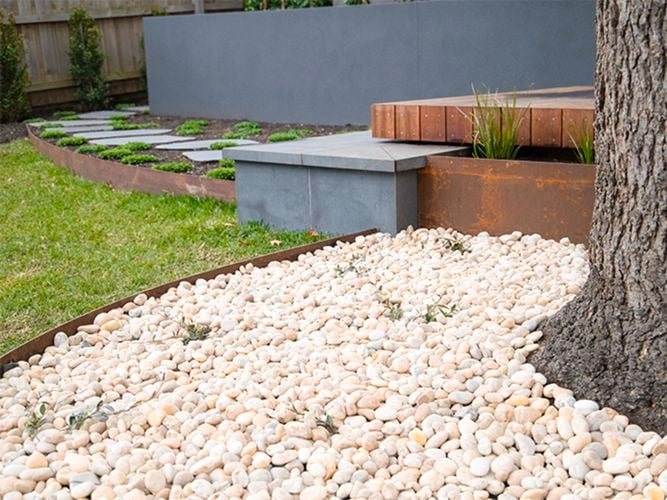 White Pebbles used as decorative landscaping for garden bed.