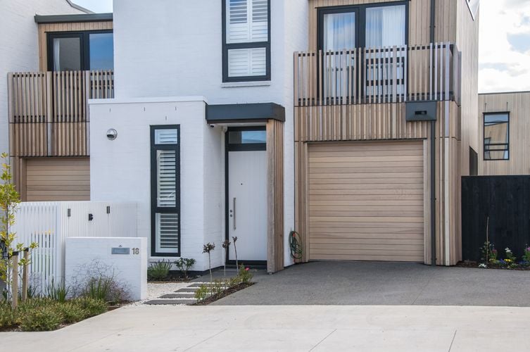 Front door to white brick and light timber unit with white wood door