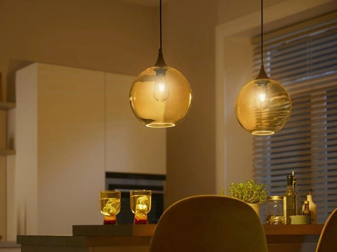 Two glass pendants hanging over a kitchen bench