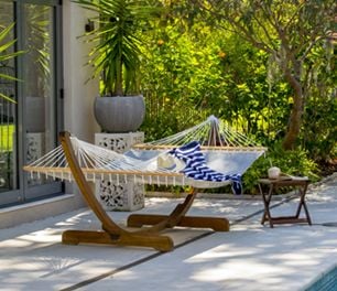 A freestanding hammock in a stone outdoor area