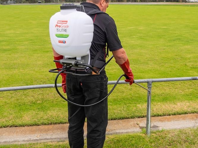Backpack sprayer being used on field and gutters