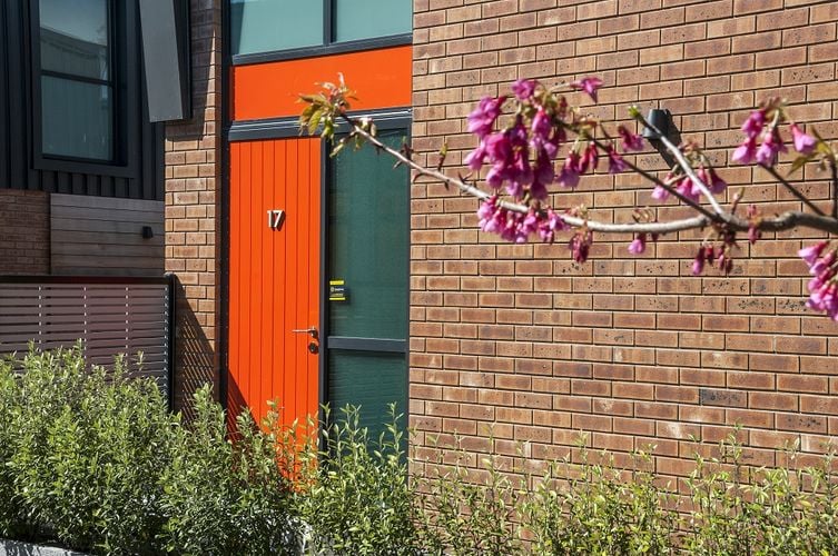 Front entryway to brick home with orange front door