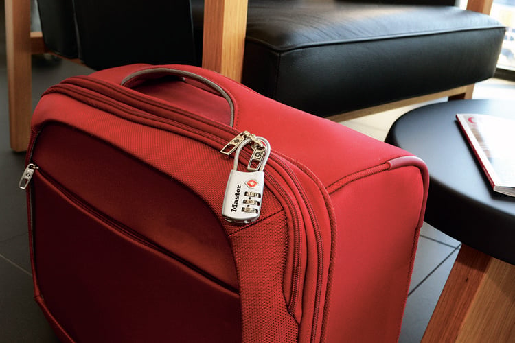 Luggage lock attached to red suitcase