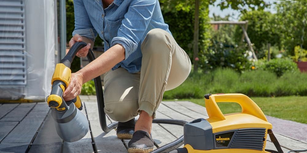 Wagner
  Flexio W690 with standard spray attachment used to spray dark gray paint to
  outdoor decking