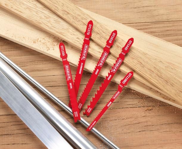 Array of jigsaw blades sitting on timber