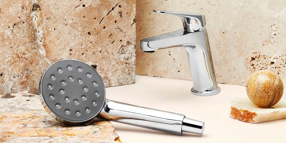 Chrome shower head and mixers styled with a neutral granite backdrop