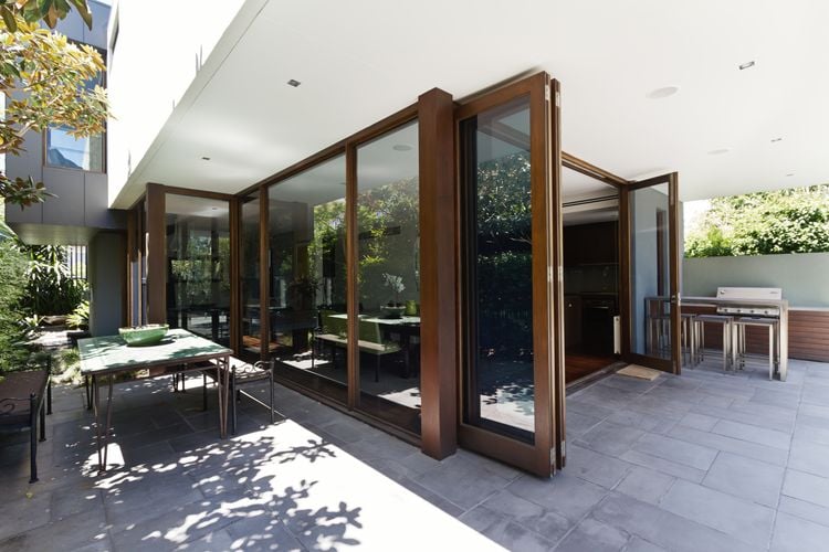 Timber folding doors opening onto tiled backyard