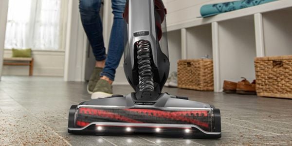 A woman efficiently cleans the floor using a Hoover Evolve cordless vacuum cleaner, ensuring a spotless and dust-free environment.
