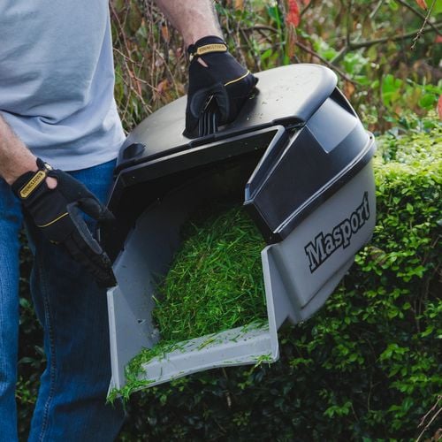 Person emptying grass clippings from lawnmower clipping container
