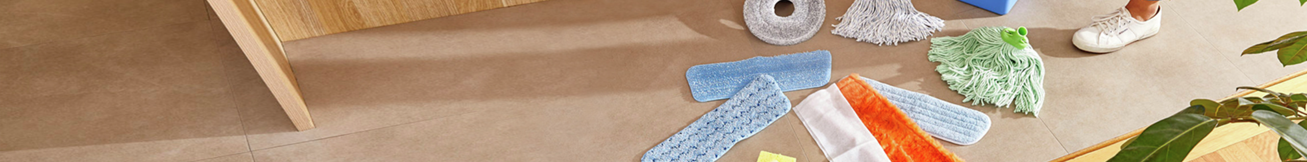 Different mop refills displayed on wooden floor.