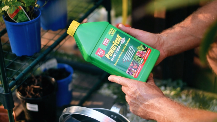 Person holding bottle of fertiliser