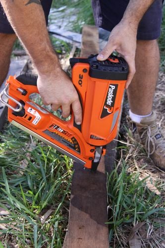 Person nailing a piece of timber using nail gun