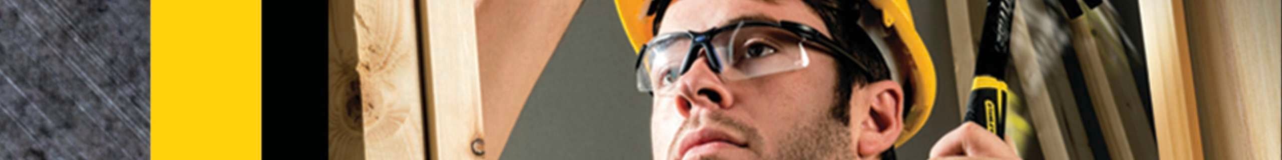 Person hammering chisel into wall frame