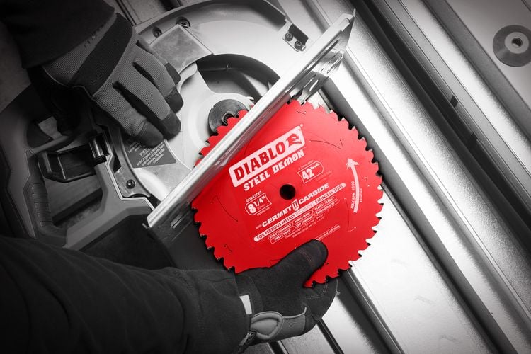 Person replacing new blade in circular saw