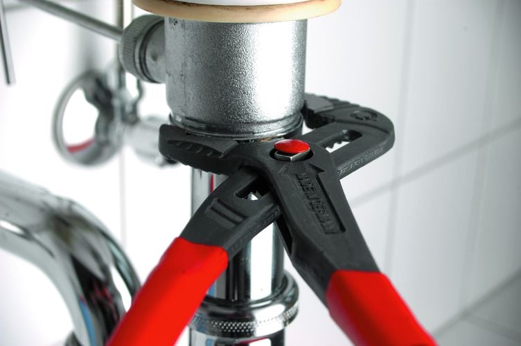 Handheld clamp tightening plumbing underneath bathroom sink