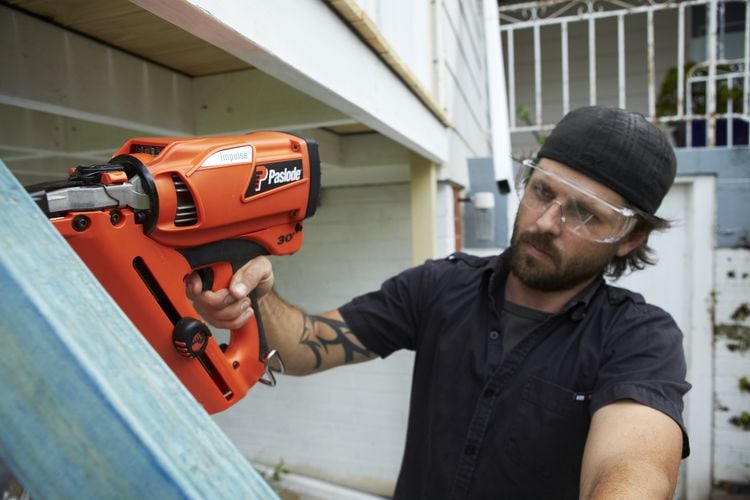 Man using nail gun to nail timber frame