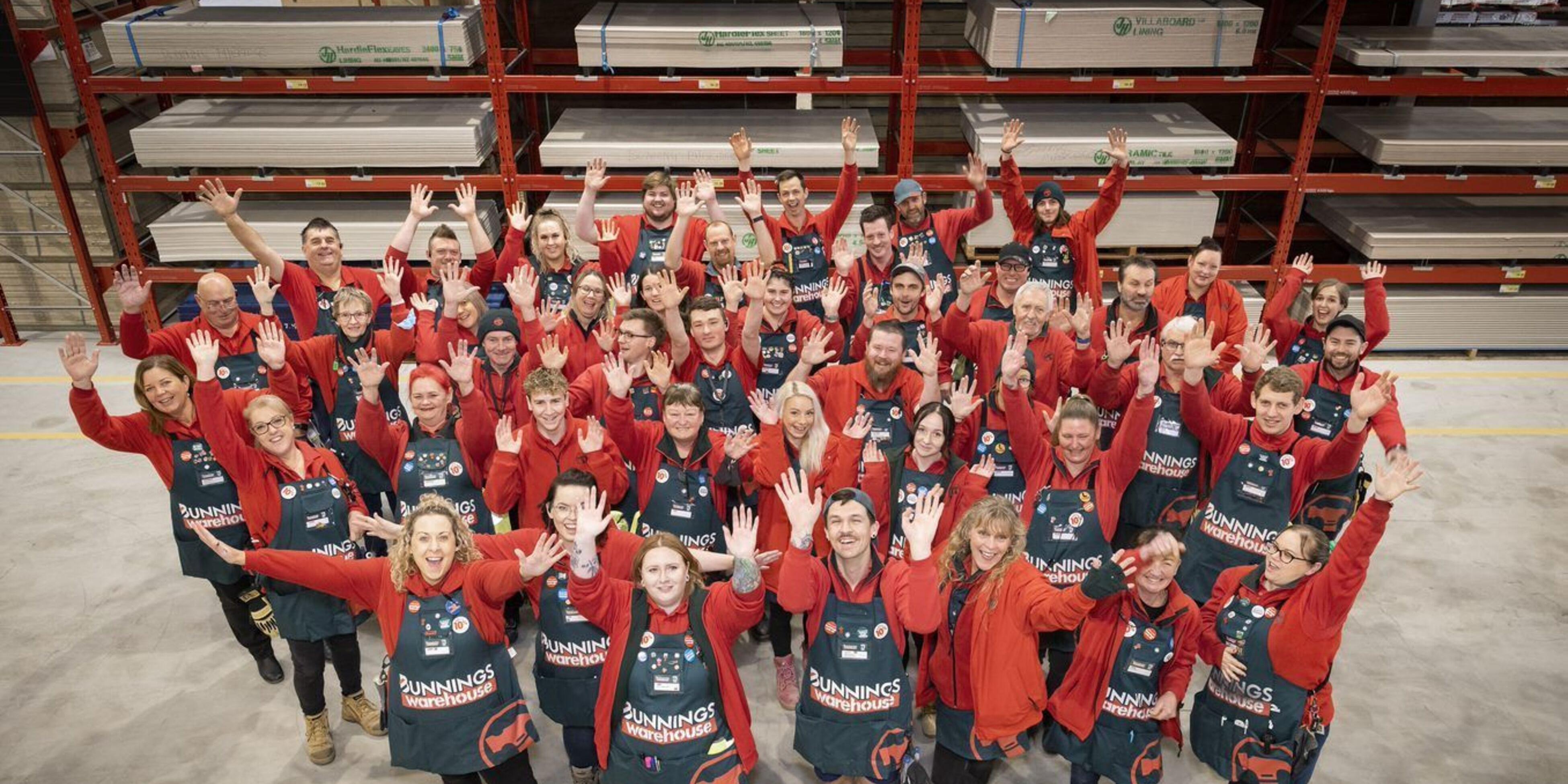 team members in a bunnings store with their hands in the air