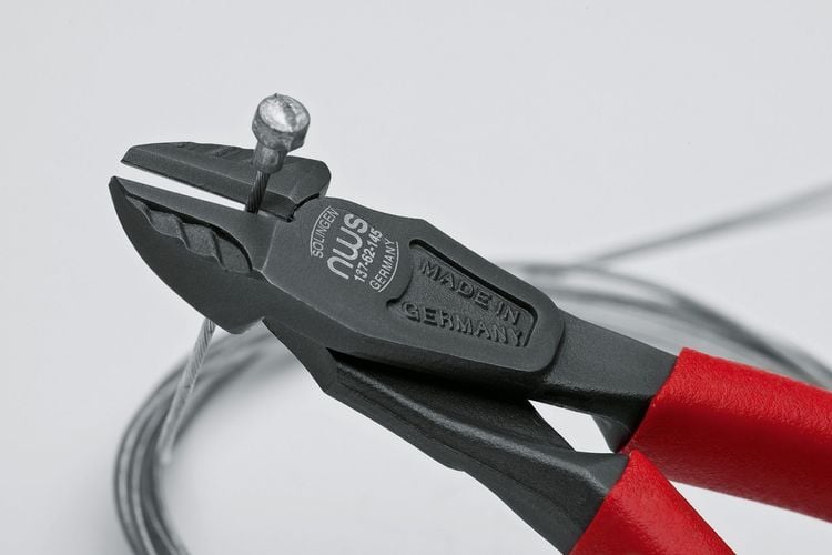 Person using cutters to cut piece of metal wiring