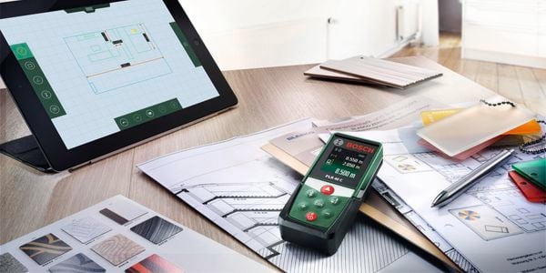 The Bosch PLR40c on a table with an IPad amongst colour swatches and paperwork.