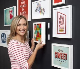 Woman standing next to pictures hung on a wall