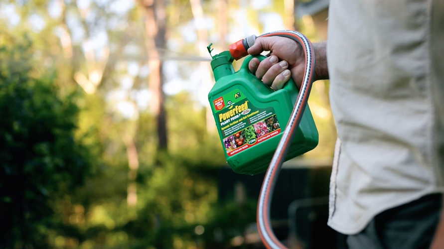 Person using fertiliser attached to watering hose