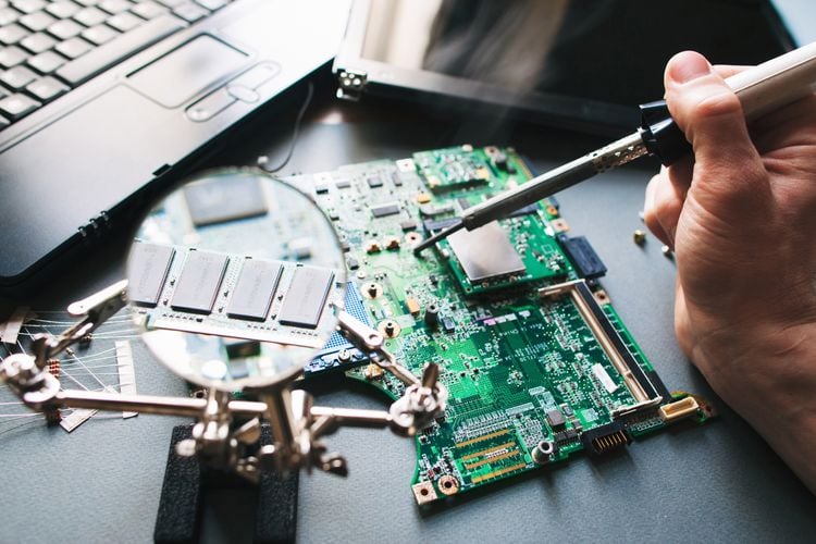A Tradeflame soldering iron soldering a computer board