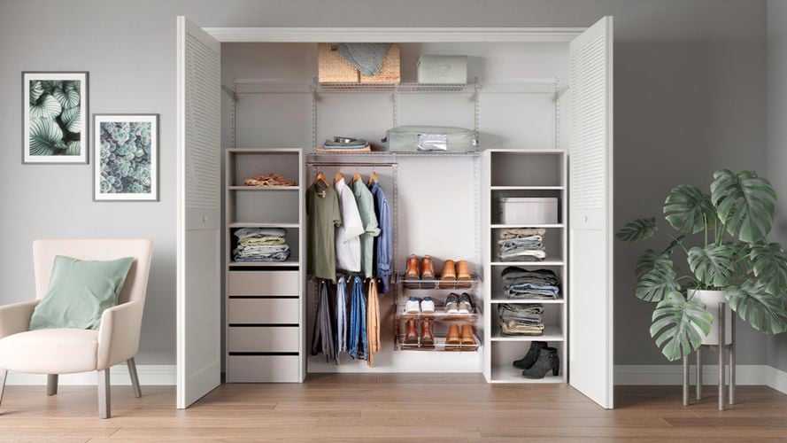 Organized built in wardrobe in room with chair and plant. 