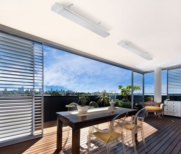 Outdoor timber decking area with dining table and outdoor heaters