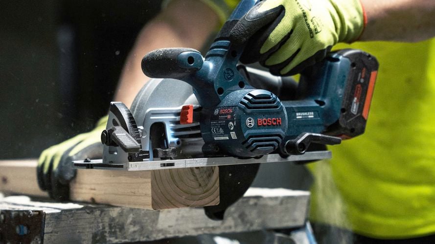 Person cutting timber with the GKS  18V-57-2 18V brushless circular saw.