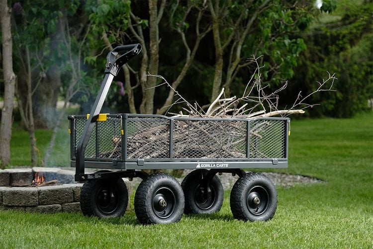 Cart full of firewood next to lit fire