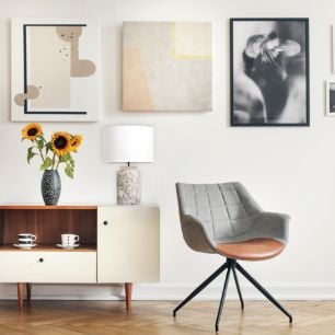 Reading spot with a chair next to a cabinet with a vase and lamp