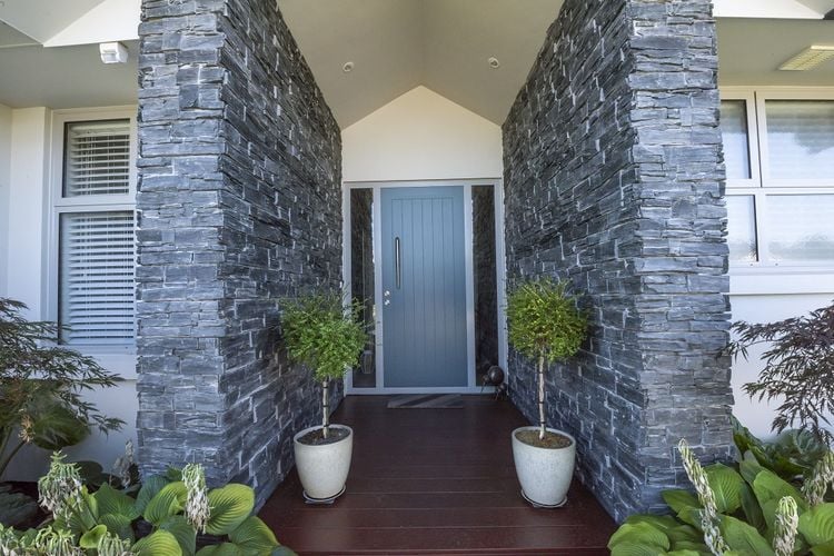 Front doorway house entry with timber decking and light blue door with large handle