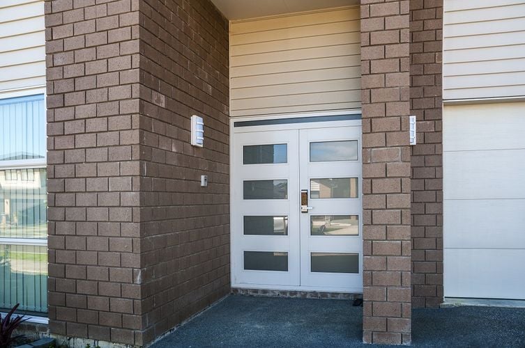 Front entryway to home with white double doors