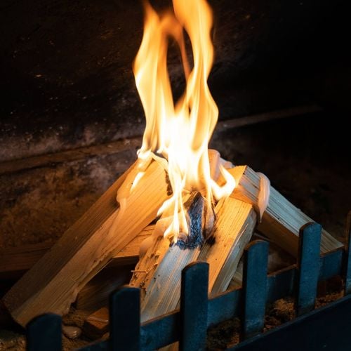 Fireplace with lit fire in teepee