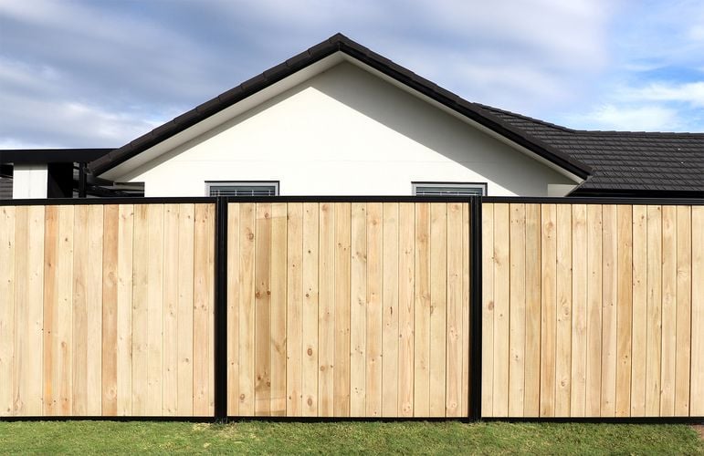 Tall laminated timber fence in front of house