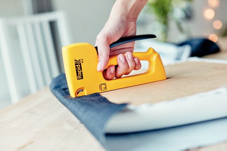 Person stapling fabric to chair cushion