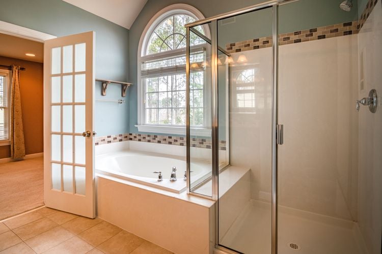 Bathroom with separate bath and shower with white door with windows